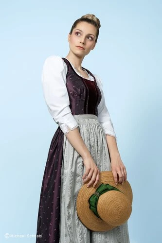 Violettes Dirndlkleid mit grauer Schürze