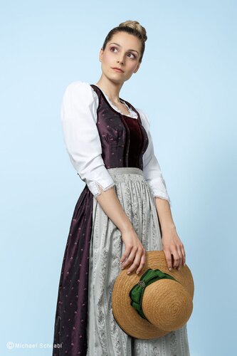 Violettes Dirndlkleid mit grauer Schürze